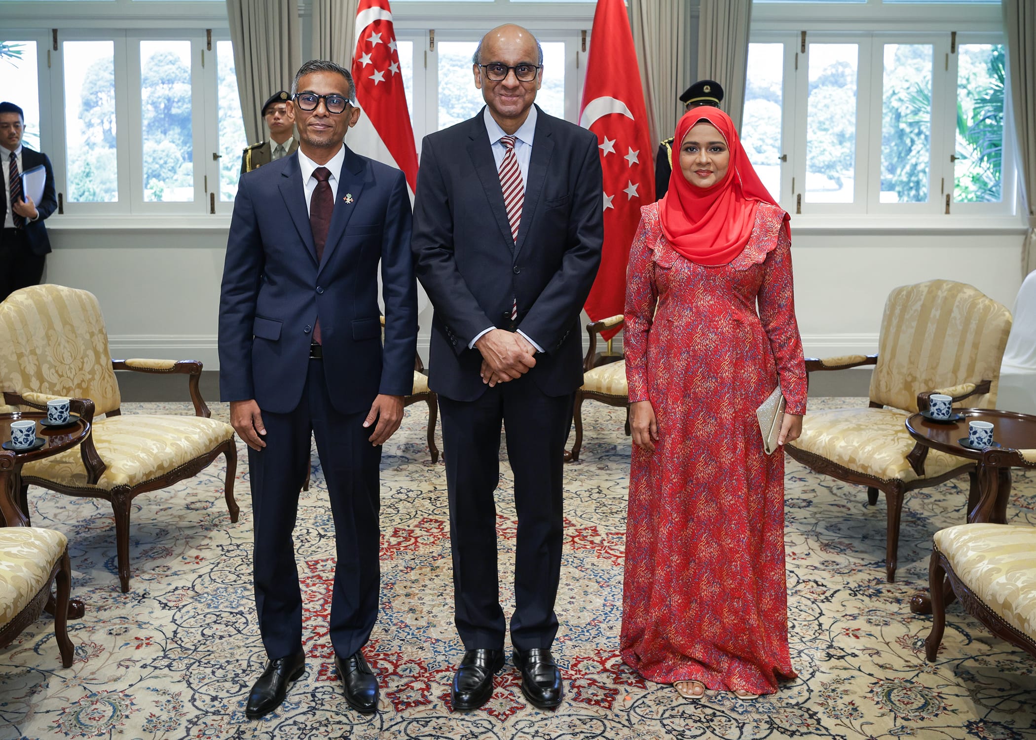 Singapore's President Tharman Shanmugaratnam with two others, posing with flags.